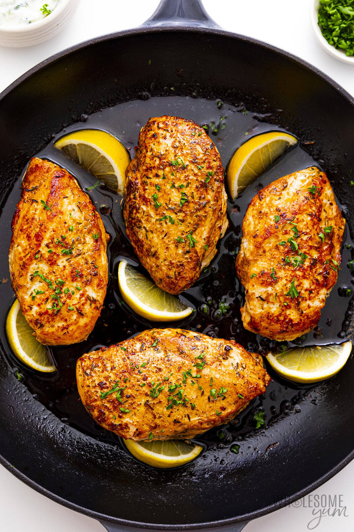 Golden, juicy Greek yogurt marinated chicken in a skillet.