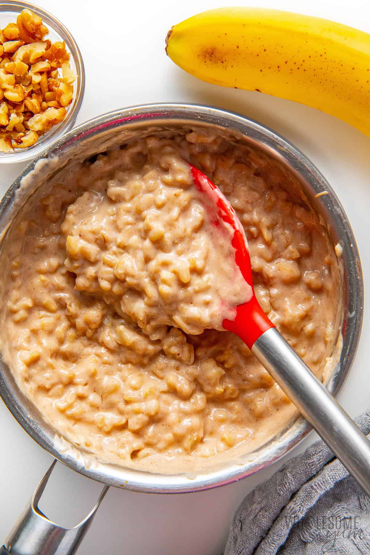 Thick, creamy banana oatmeal in a saucepan.