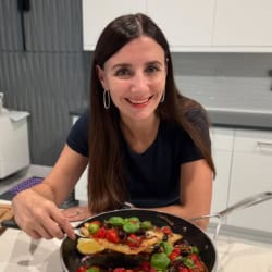 Maya serving barramundi from a skillet.