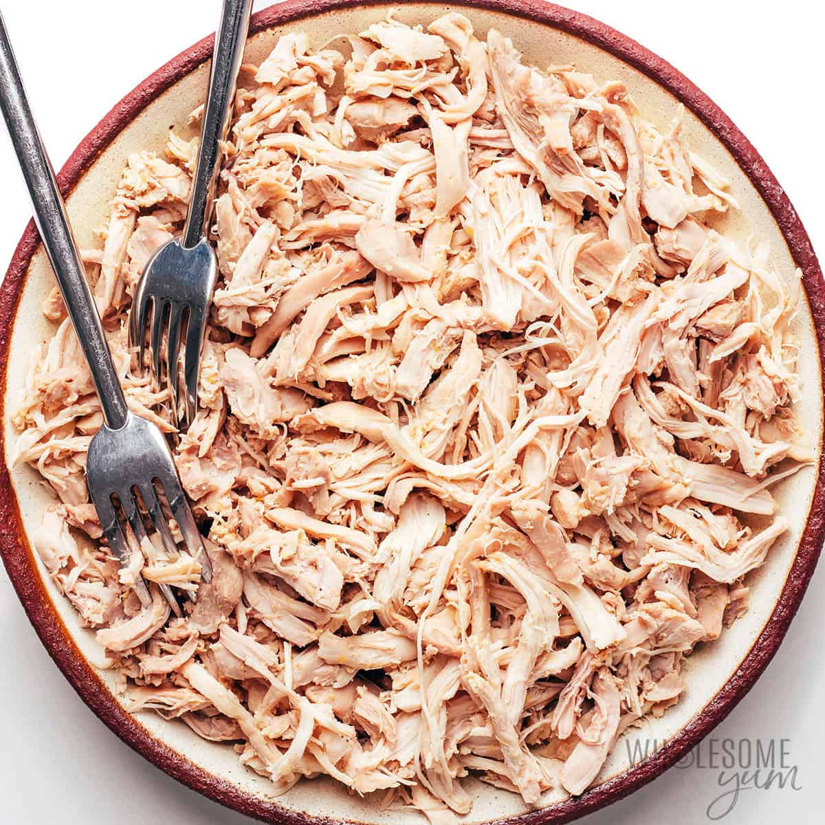 Shredded chicken on a plate with forks.