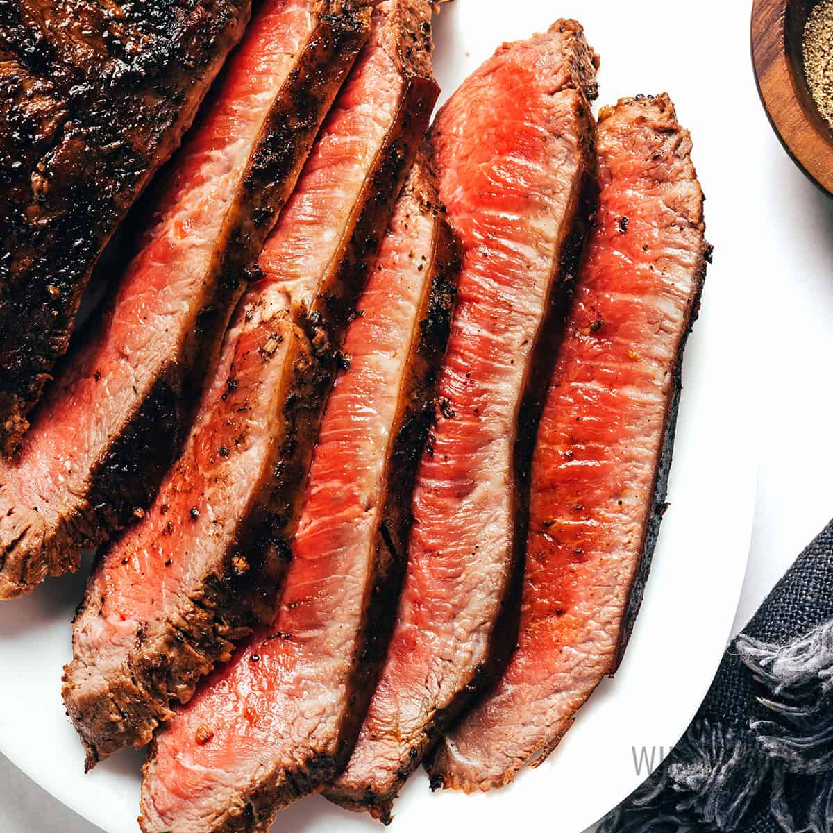 Flat iron steak, sliced on a plate.