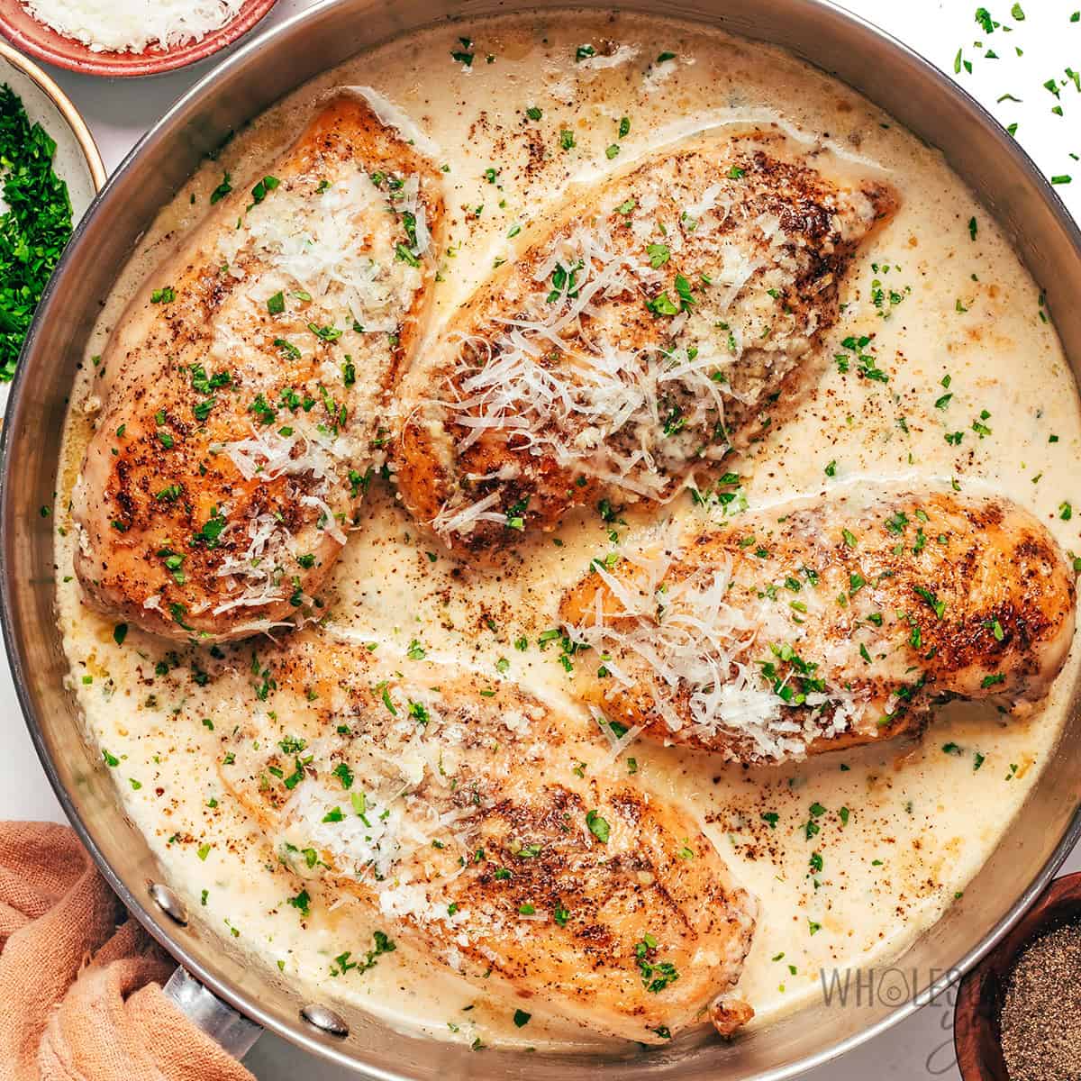 Finished garlic parmesan chicken recipe, topped with parsley and extra parmesan.
