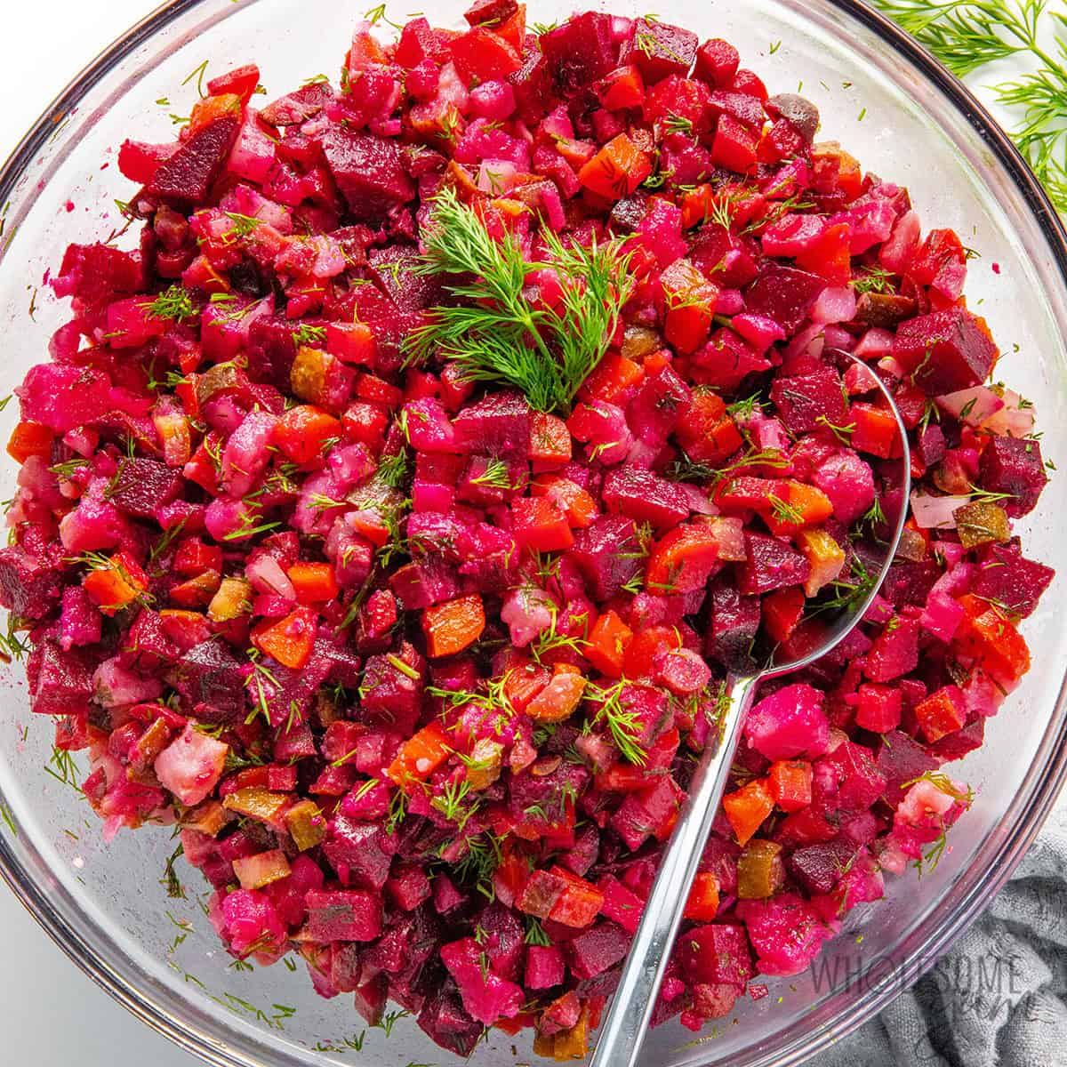 Finished Russian salad recipe after chilling, garnished with fresh dill.