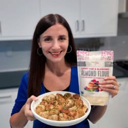 Maya holding a plate of turkey meatballs and a bag of almond flour.