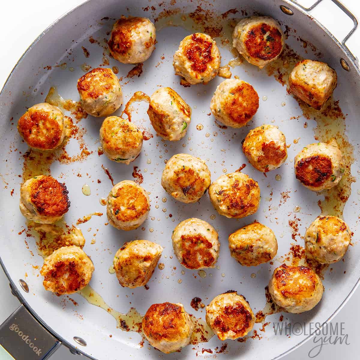 Browning meatballs in a skillet.