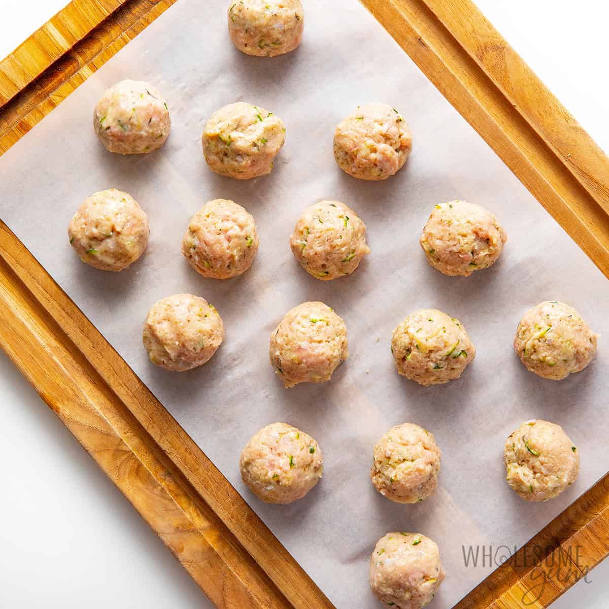 Formed turkey meatballs on a cutting board.