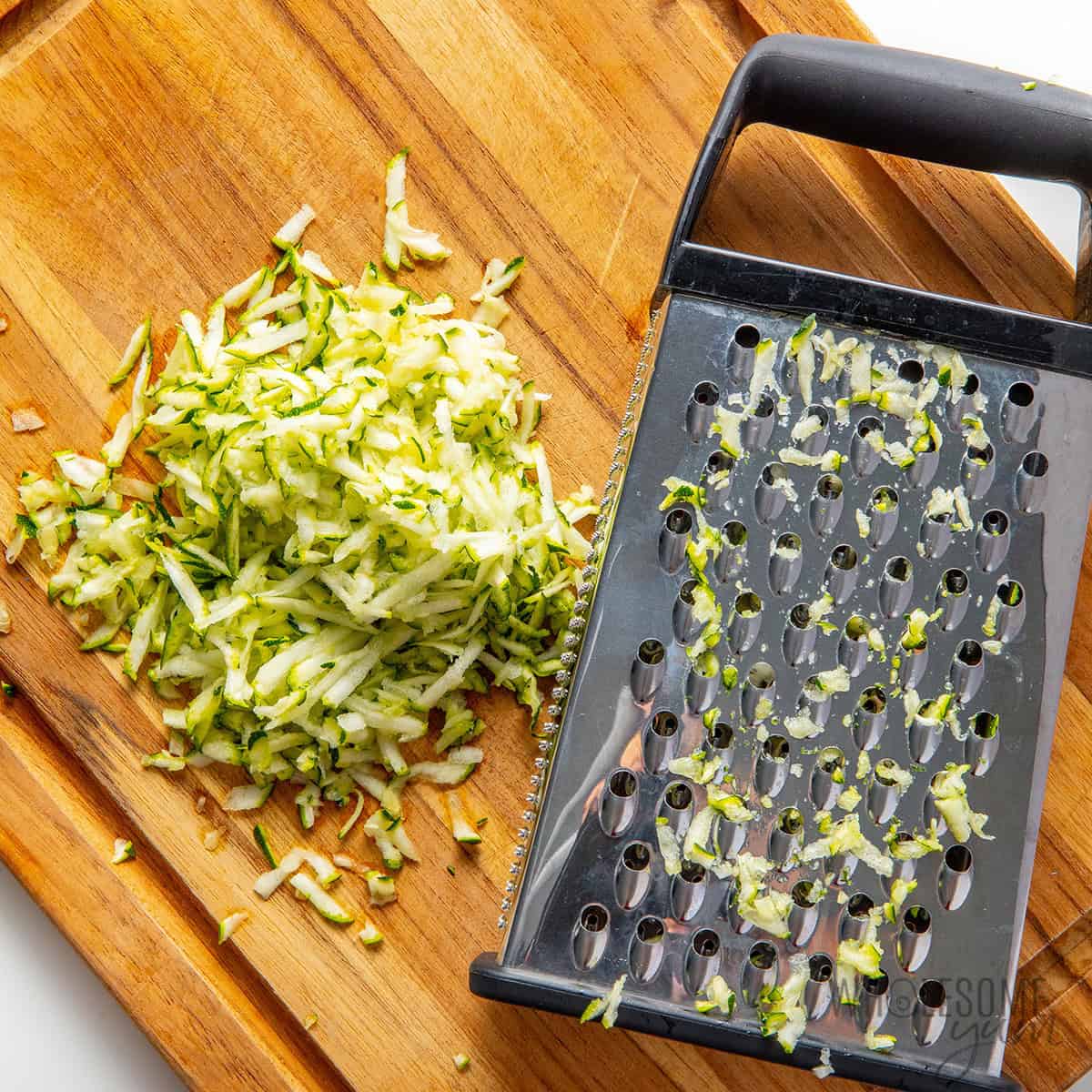 Grating zucchini on a cutting board.
