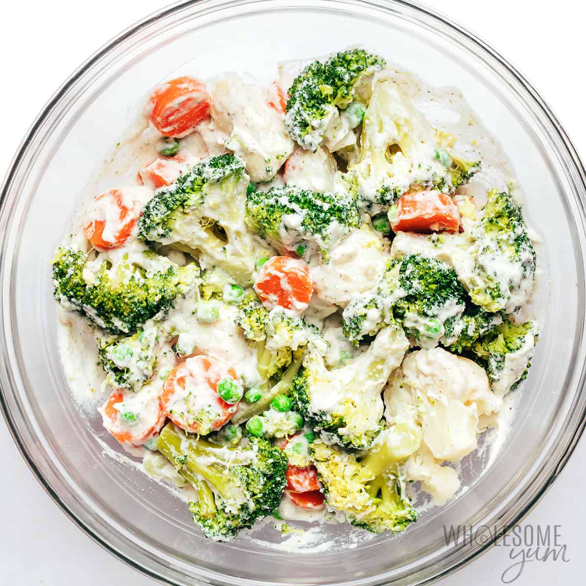 Mixing vegetables and sauce in a bowl.