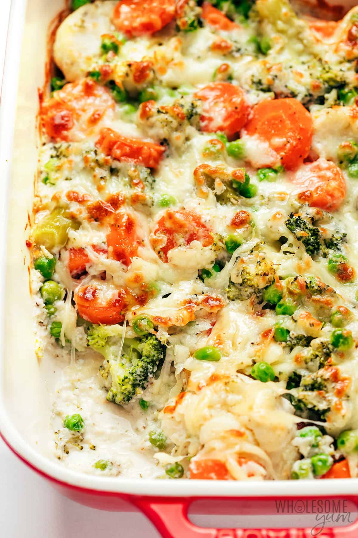 Serving the creamy, cheesy vegetable casserole with a scoop taken out.