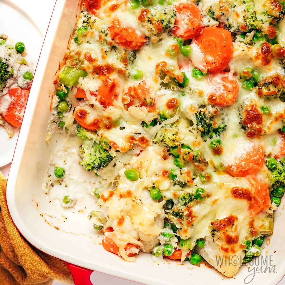 Baked vegetable casserole recipe with a piece removed.
