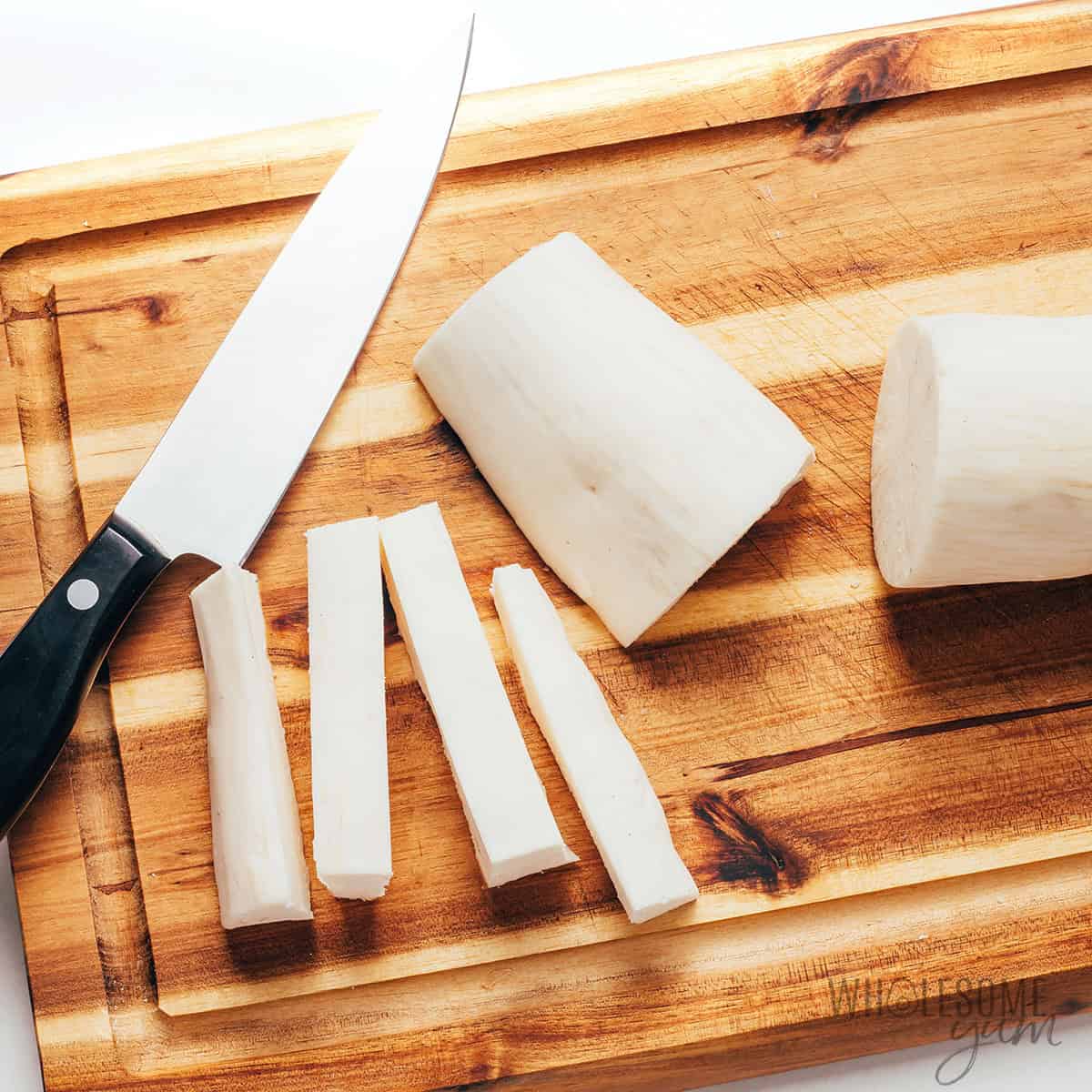 Cutting the yuca root strips from the whole root.