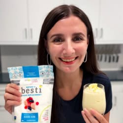 Maya holding a cup of creamy lemon mousse and a bag of Besti Powdered.