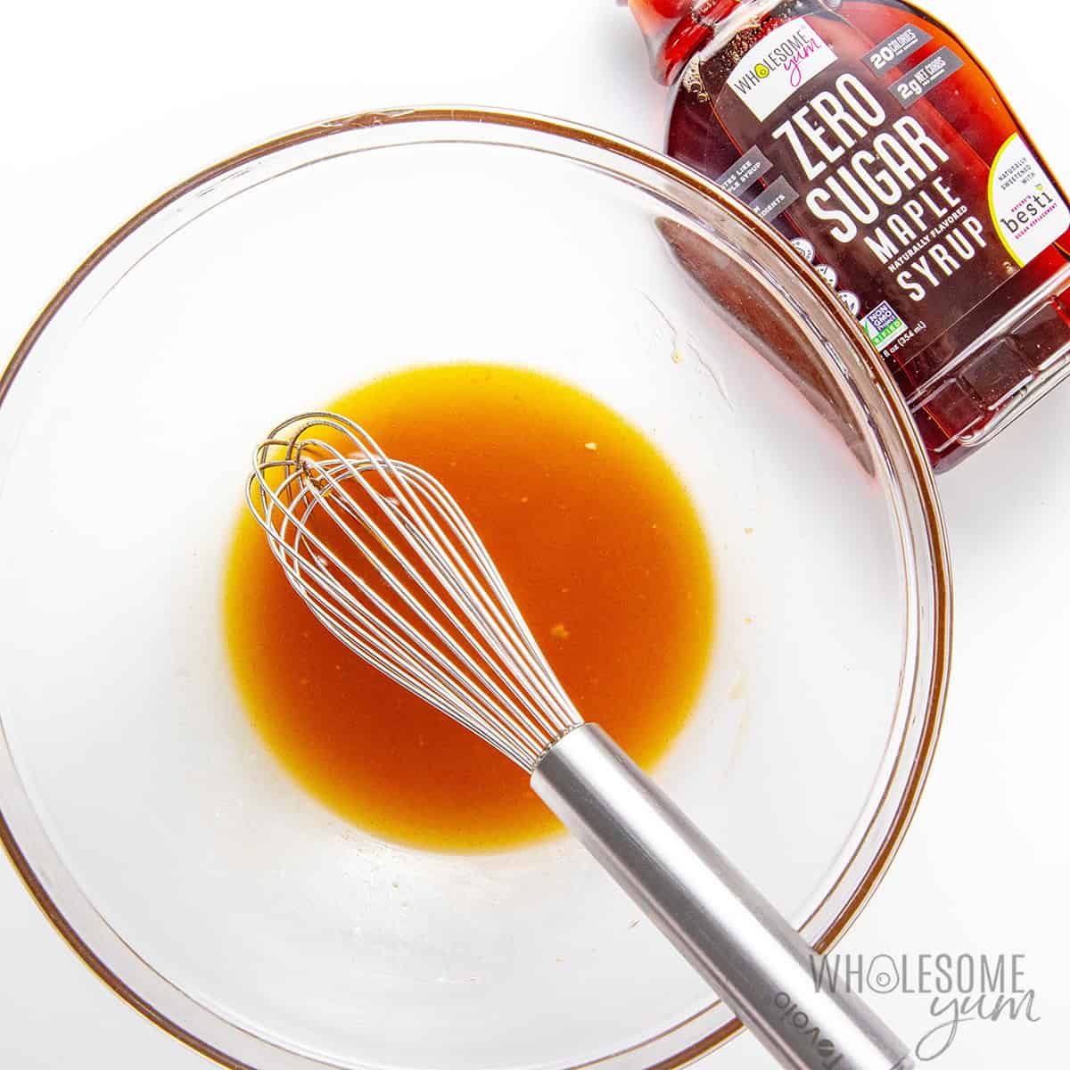 Whisking glaze ingredients together in a bowl.