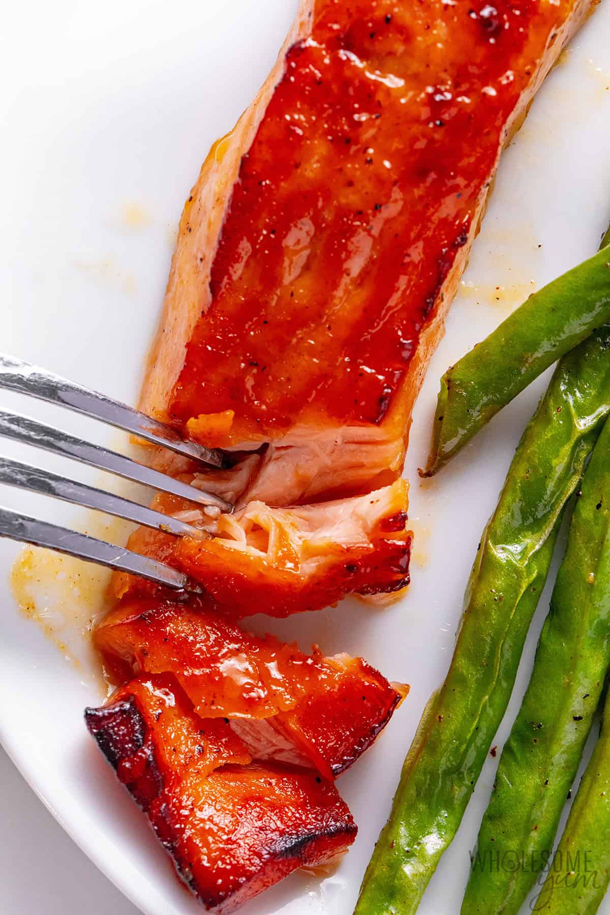 Golden, sticky maple glazed salmon flaked with a fork.