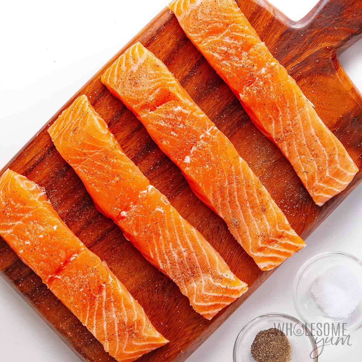 Seasoned fish on a cutting board.