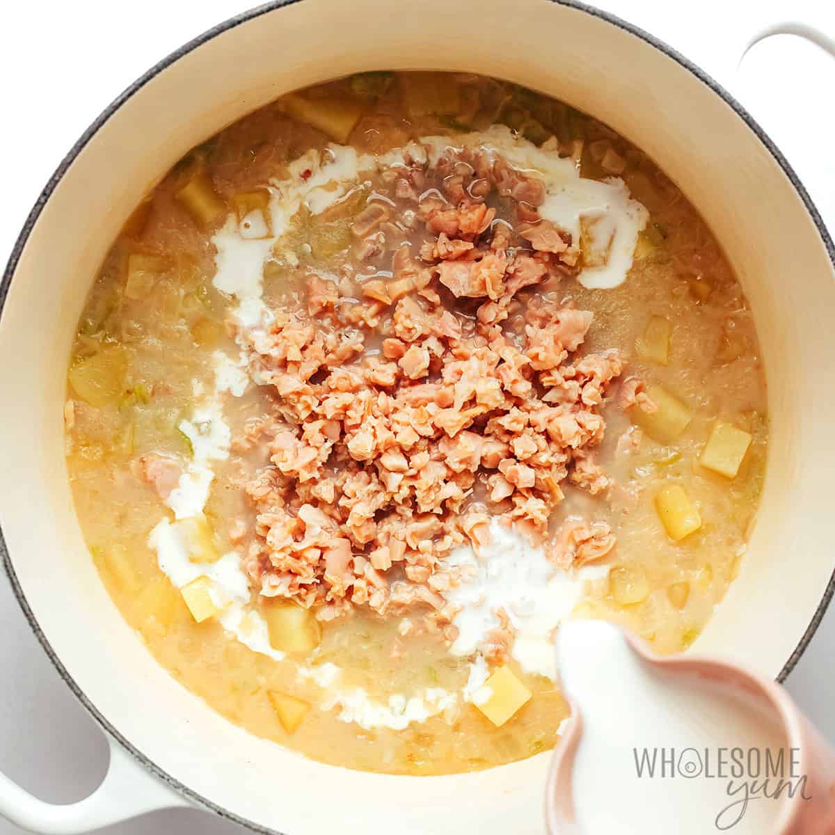 Clams and half & half stirred into the clam chowder soup.