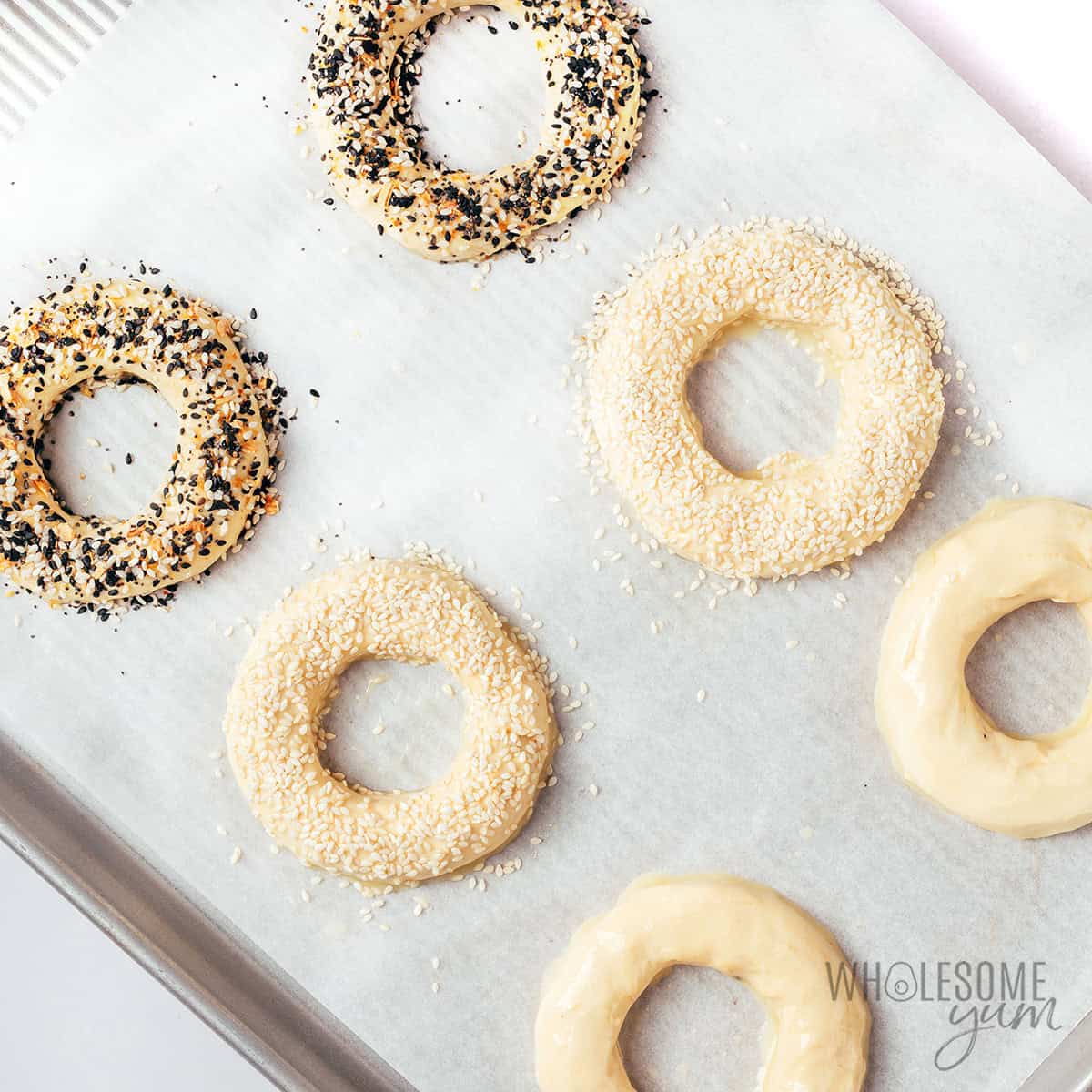 Bagel shaped dough on a baking sheet.