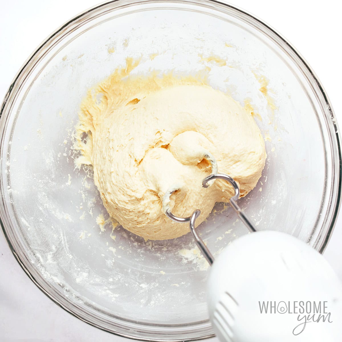 Kneading the cottage cheese bagel dough in a bowl.