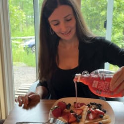 Maya pouring berry syrup over almond flour crepes.