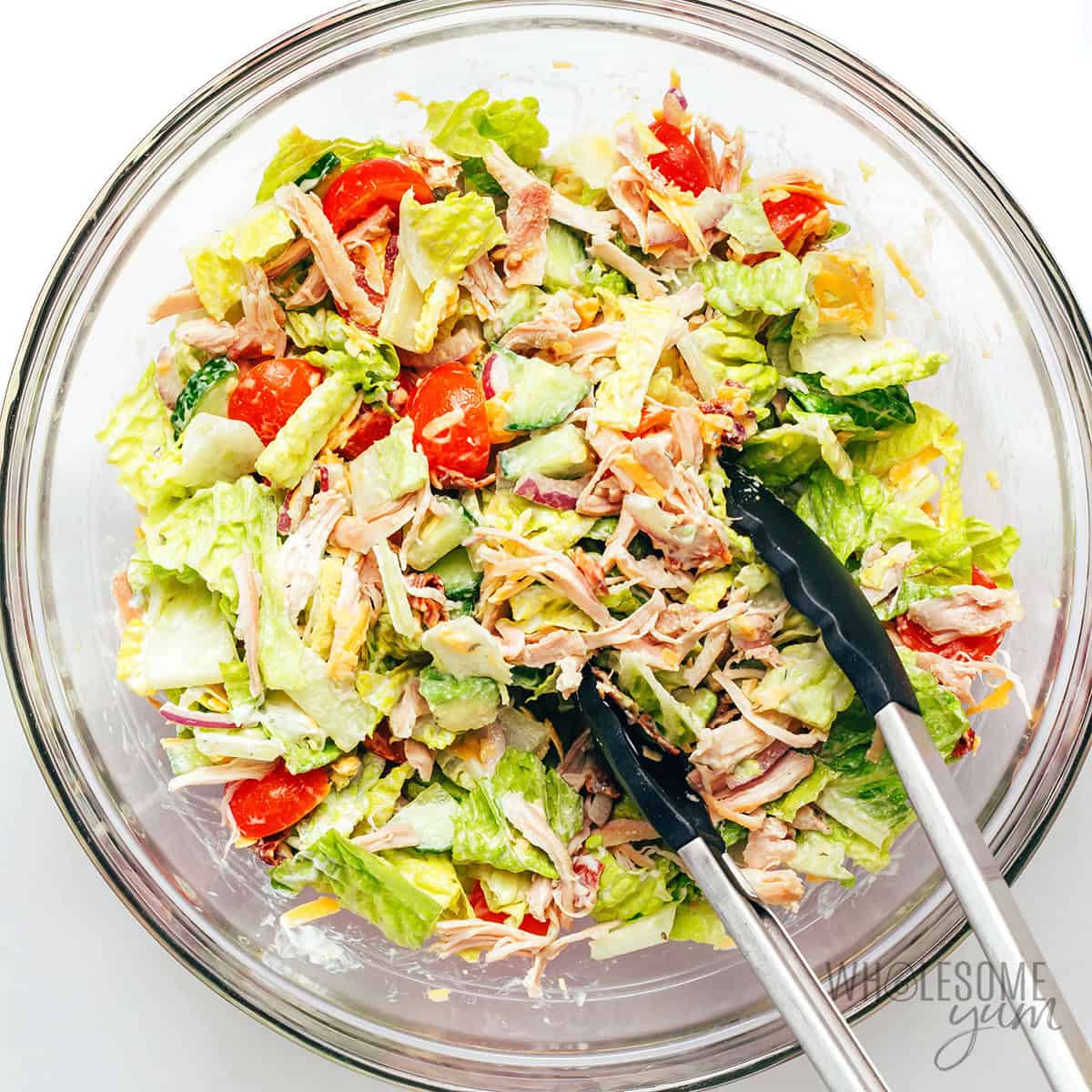 Chicken bacon ranch salad tossed together with tongs.