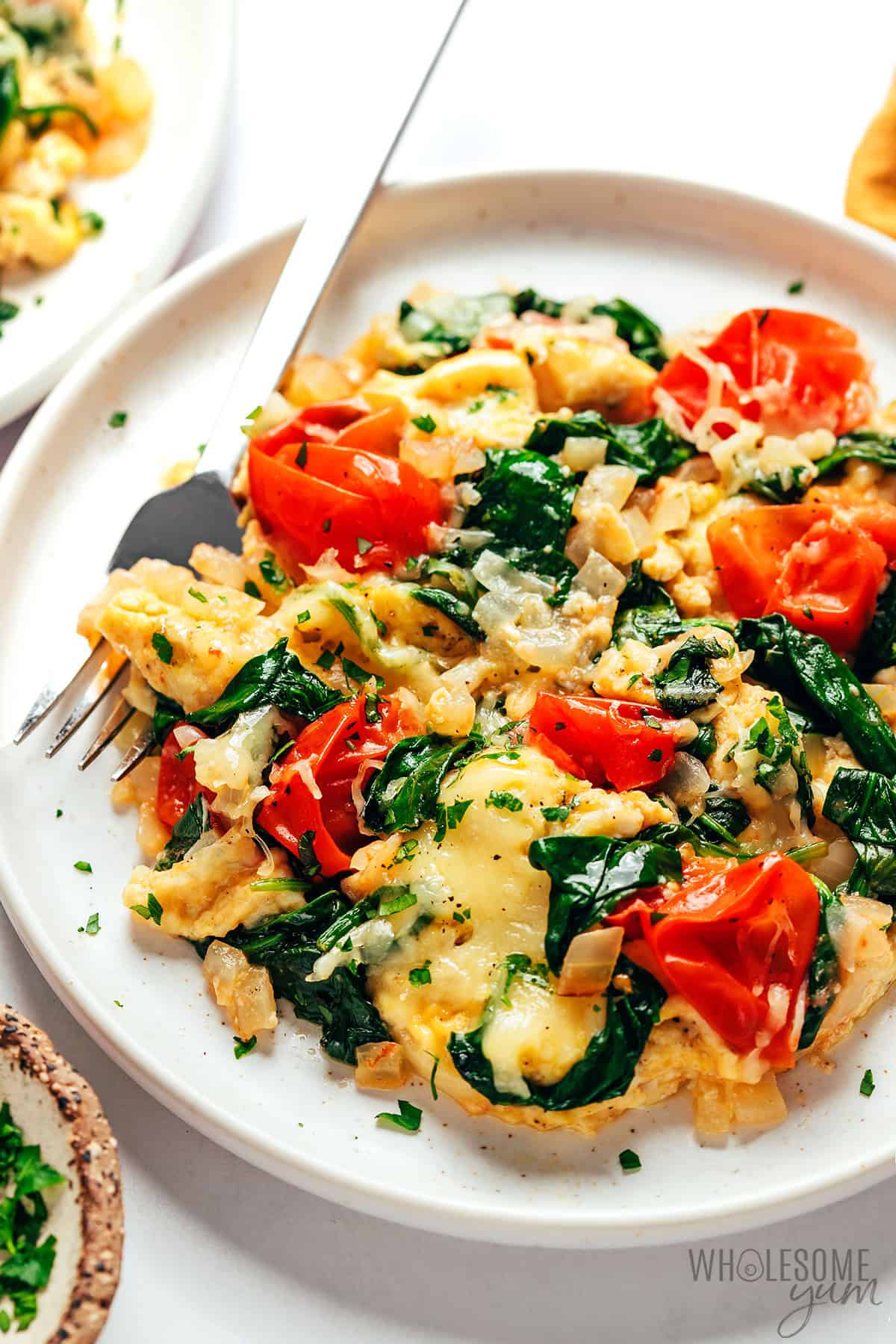 Veggie breakfast scramble on a plate with a fork.