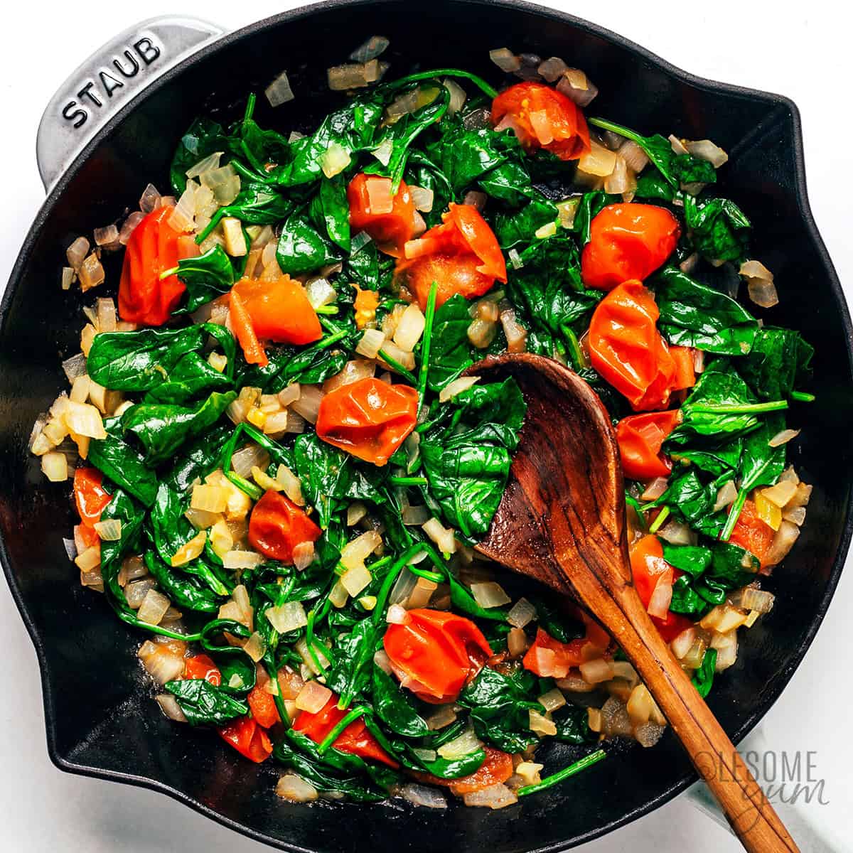 Spinach wilted with tomatoes and onions.