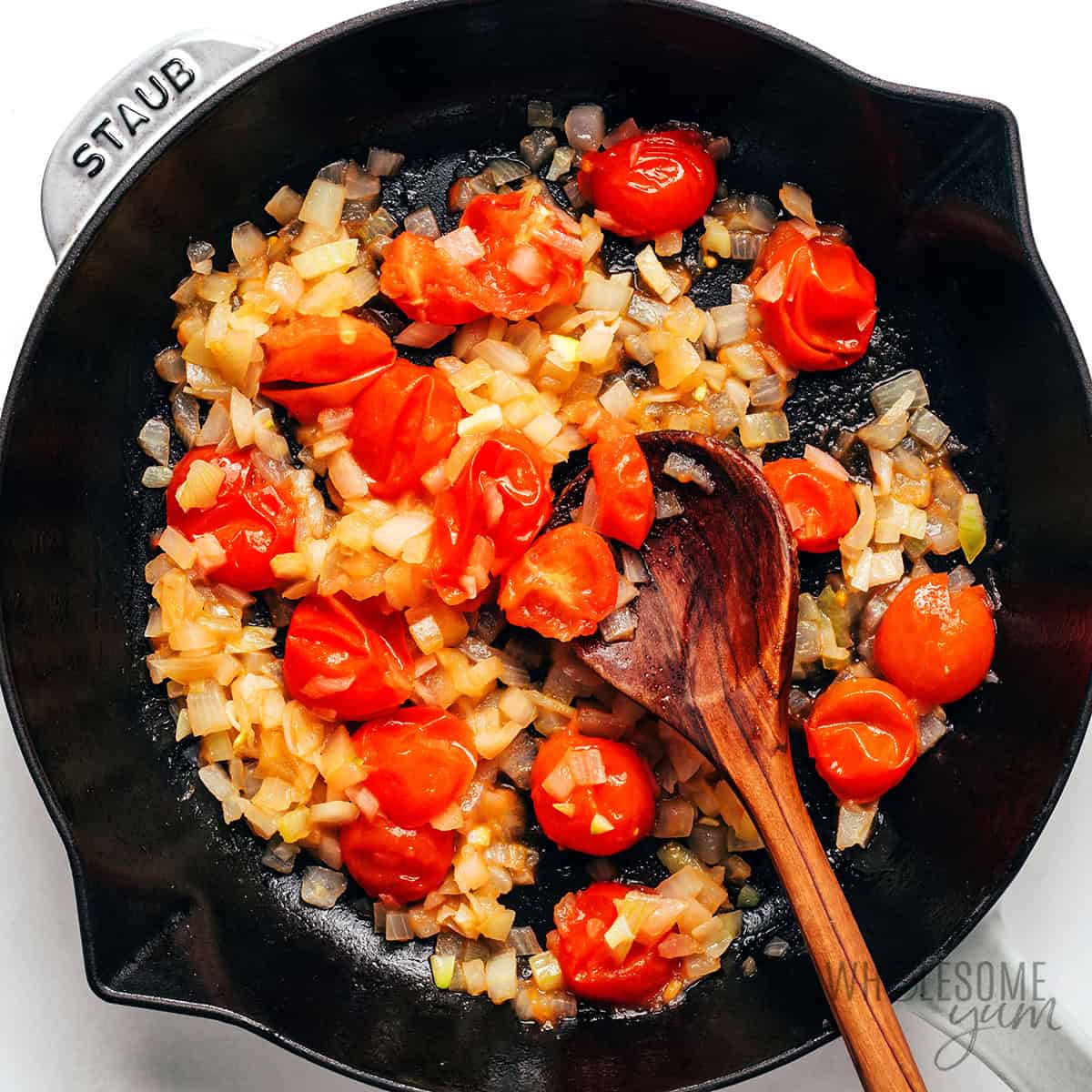 Sauteed tomatoes and onions in a skillet.