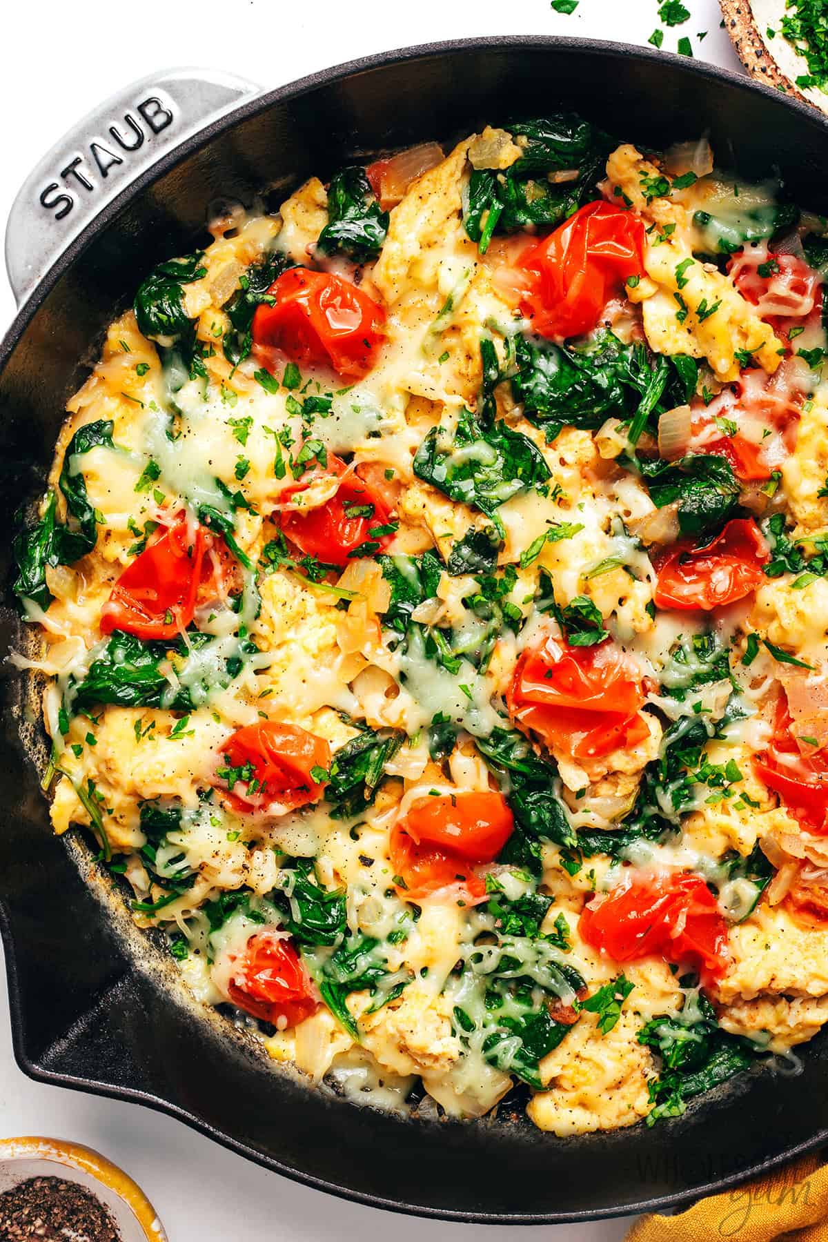 Finished breakfast scramble recipe in the skillet with cheese melted on top.