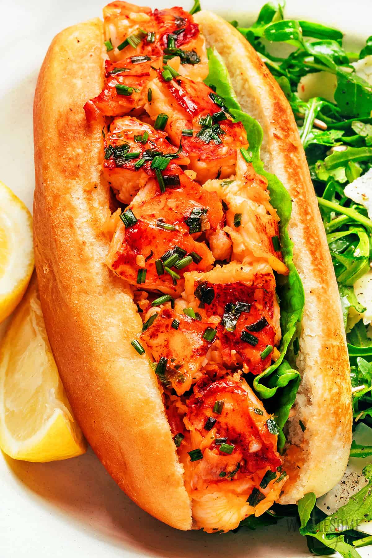 Hot, buttery Connecticut lobster roll on a plate.