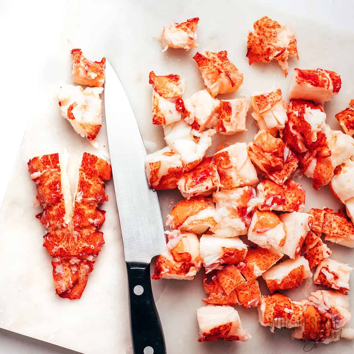 Chopping lobster into bite-sized pieces.