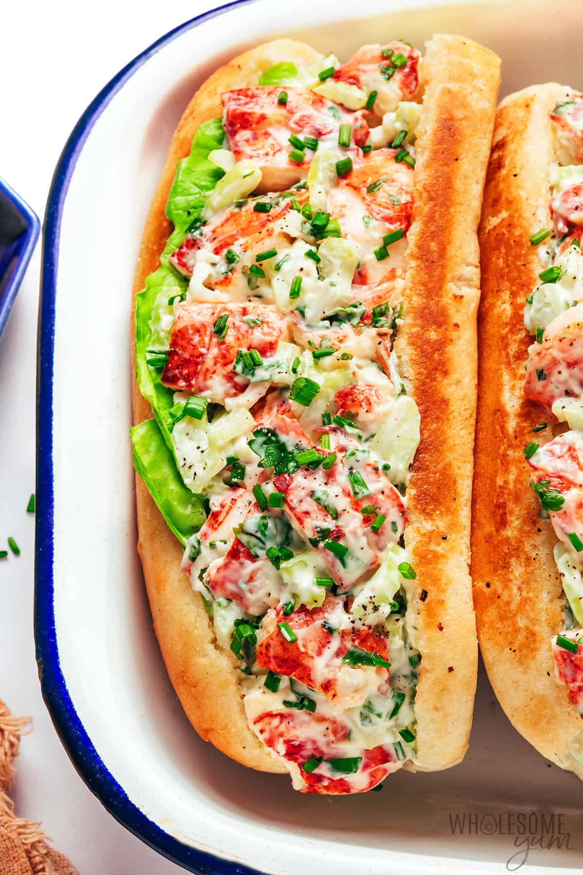 Cold, creamy lobster roll assembled with a lettuce leaf.