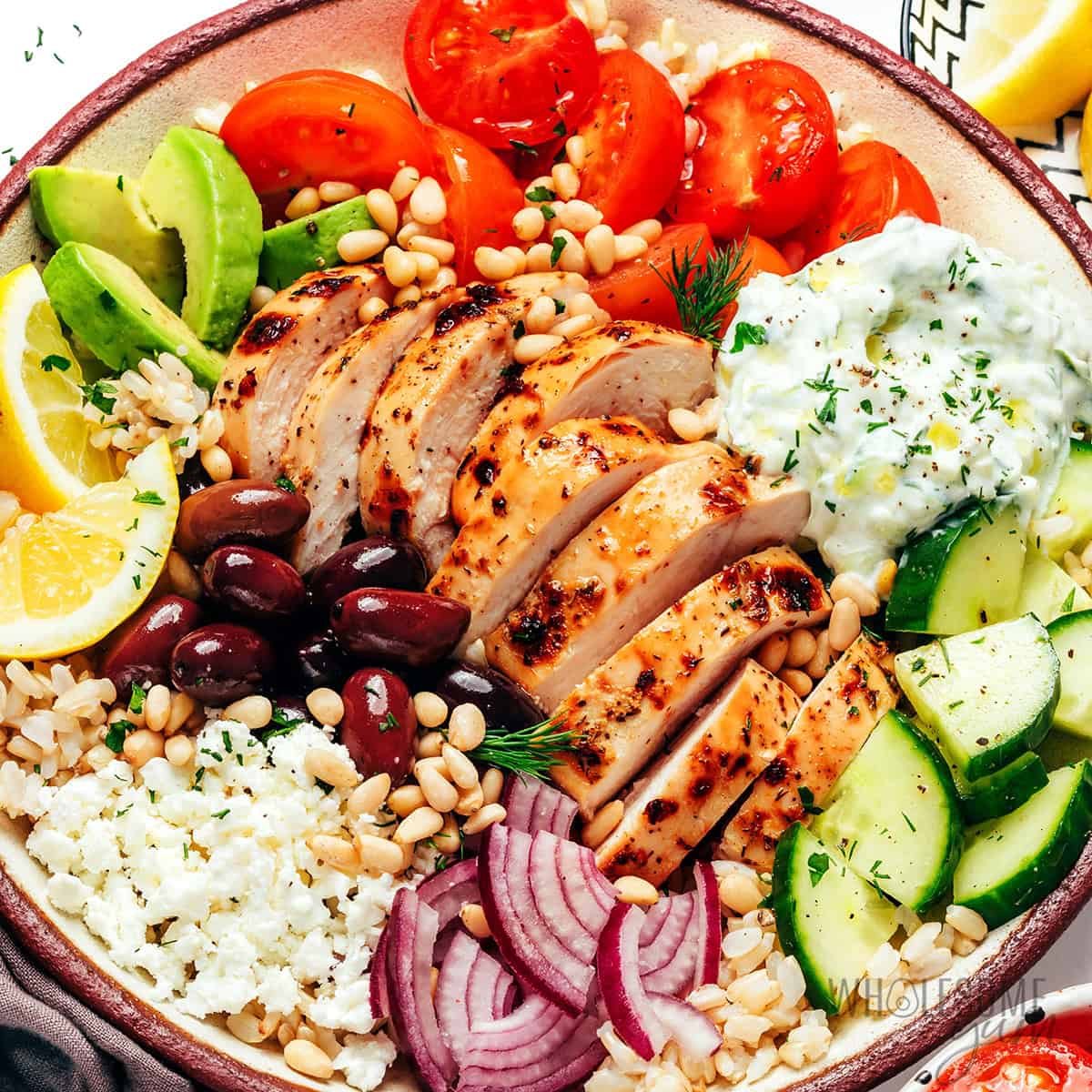 Assembled Greek chicken bowl recipe with all the toppings.