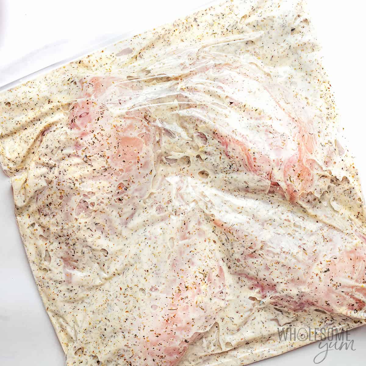 Chicken marinating in a bag.