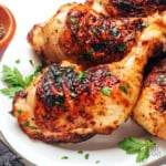 Grilled chicken quarters on a plate.