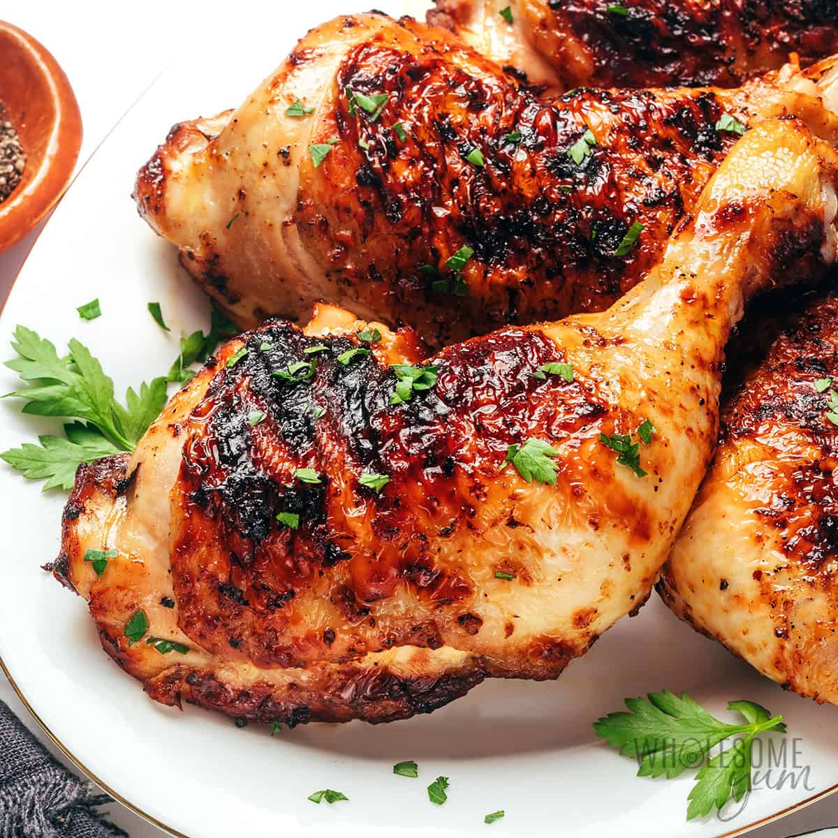Grilled chicken quarters on a plate.