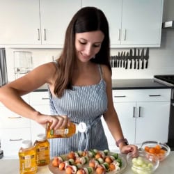 Maya drizzling prosciutto and melon appetizers with Wholesome Yum Zero Sugar Jalapeno Honey.