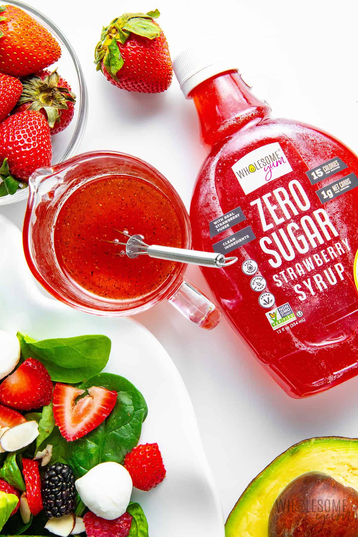 Strawberry vinaigrette dressing in a small glass pitcher, made with fresh strawberry syrup.