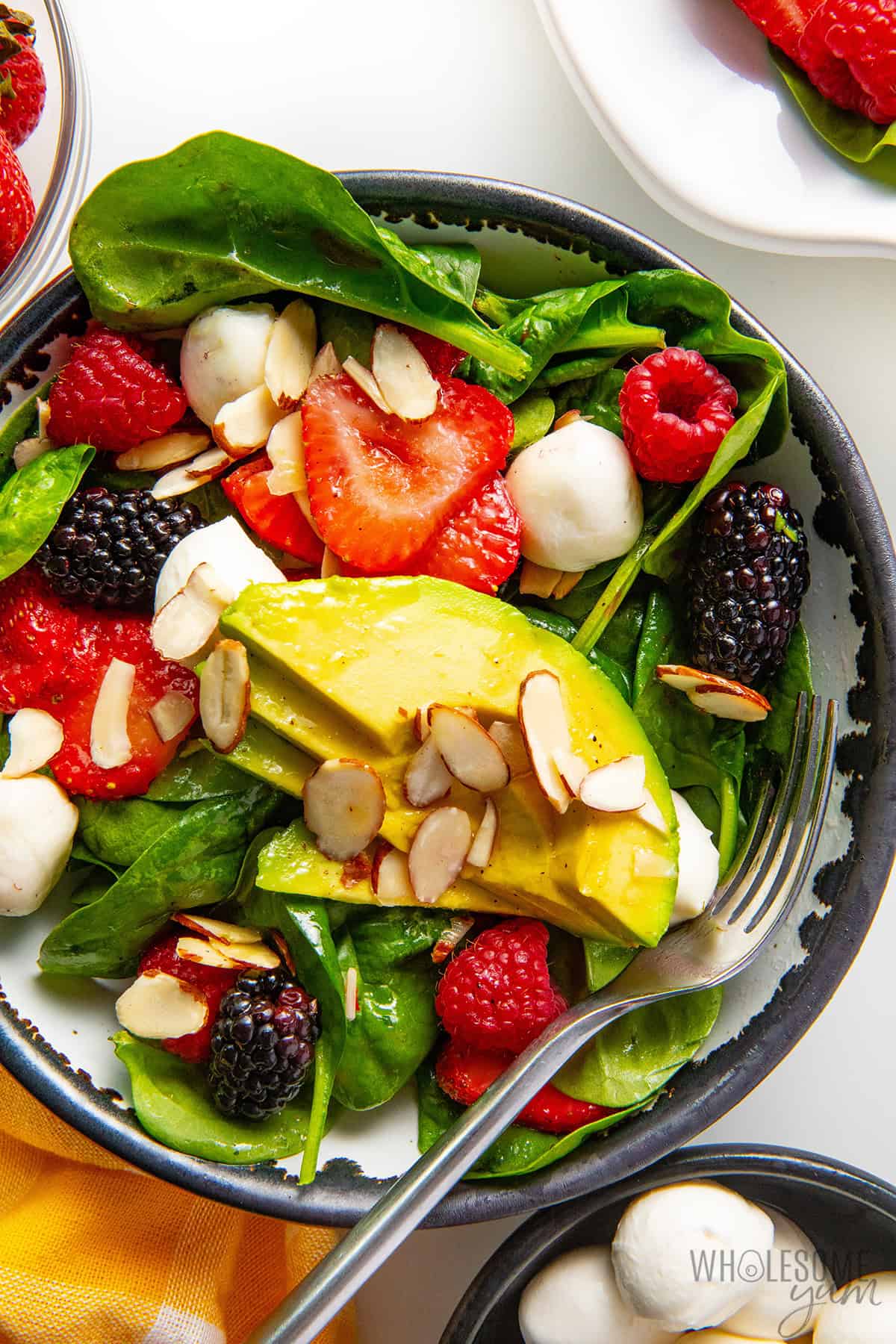 Fresh berry salad served in a bowl with a fork.