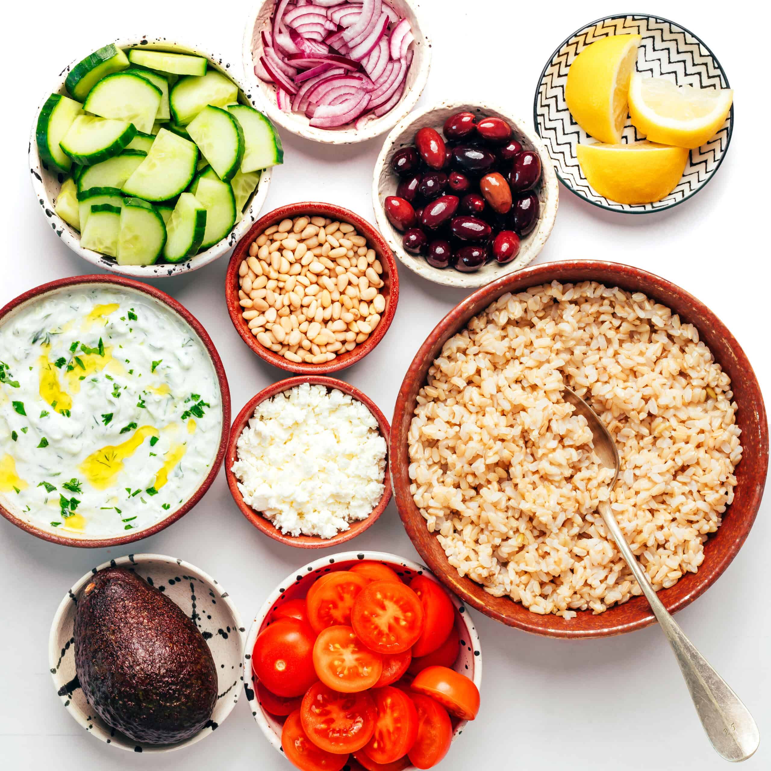 Chopped Greek chicken bowl toppings in bowls.