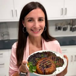 Maya holding a plate of grilled portobello mushrooms.
