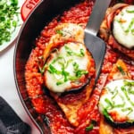 Chicken Sorrentino on a spatula in a skillet.