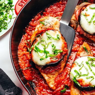 Chicken Sorrentino on a spatula in a skillet.