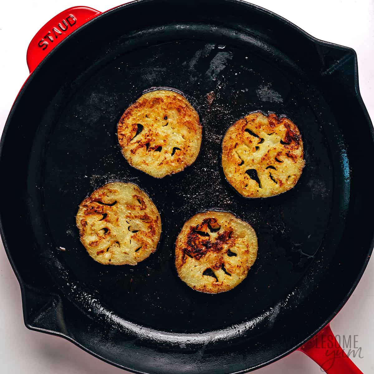 Eggplant sauteed in a skillet.