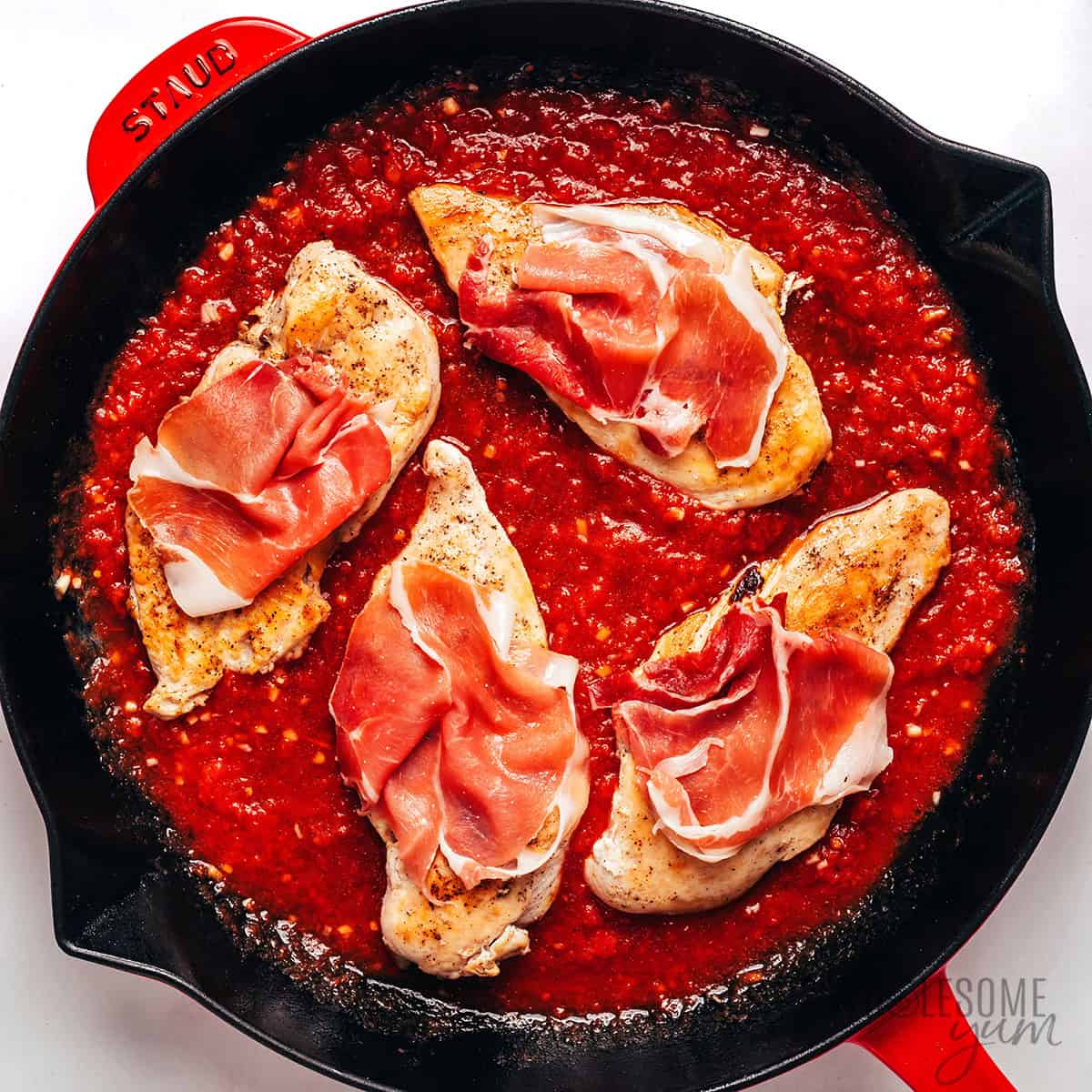 Chicken cutlets added to the sauce and topped with prosciutto.