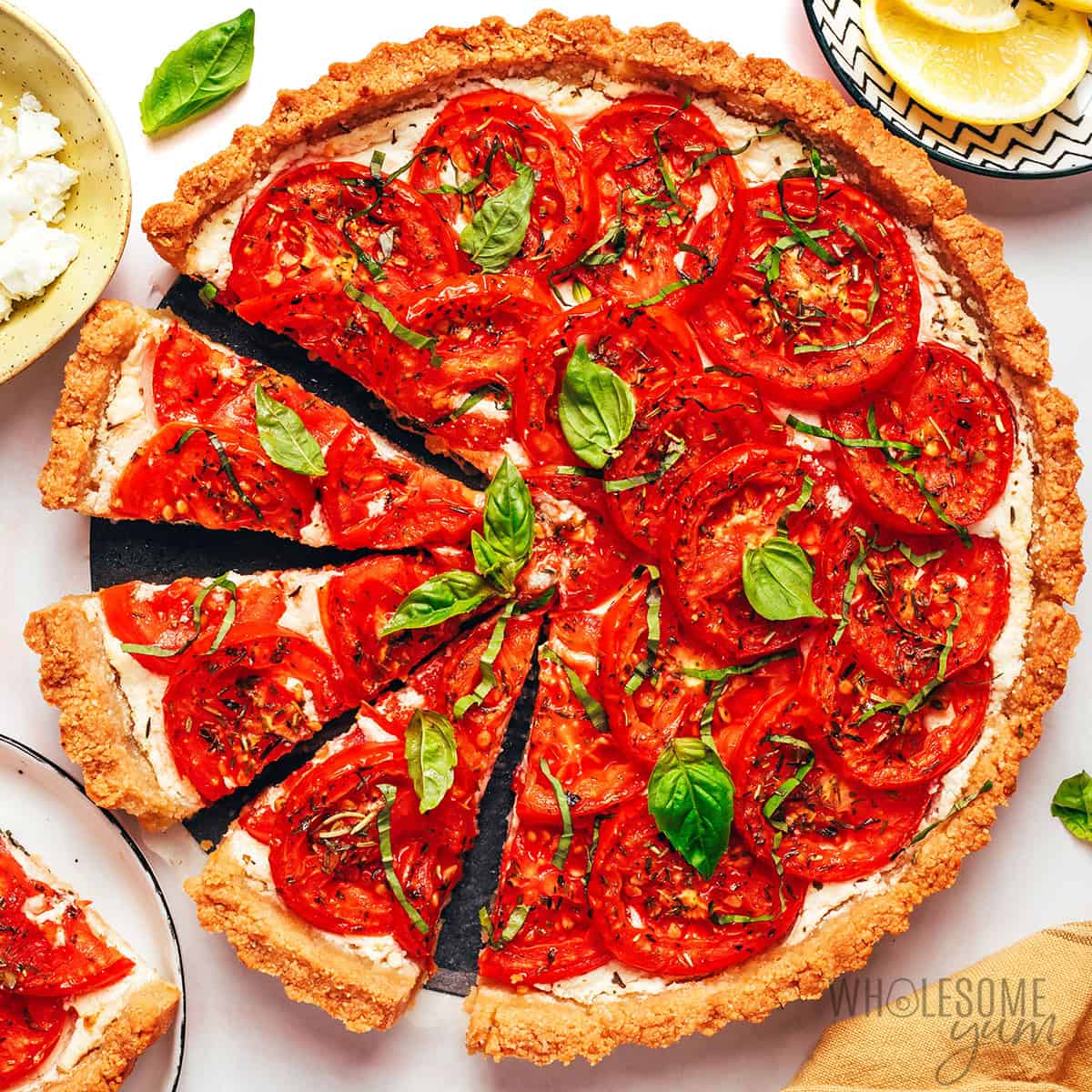 Tomato tart garnished with fresh basil cut into slices.