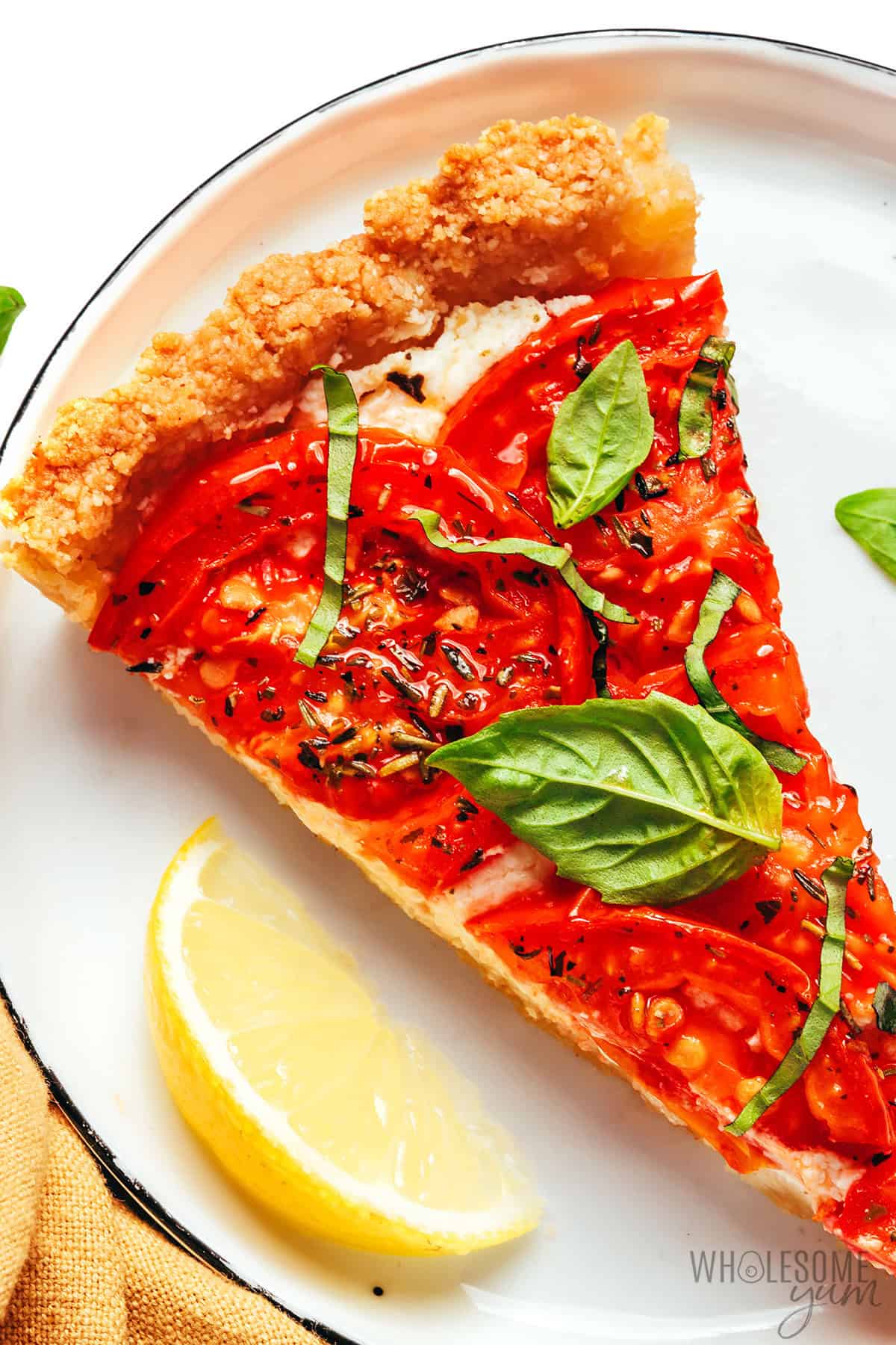 Fresh, juicy tomato tart with creamy feta filling, crisp almond crust, and fresh basil.