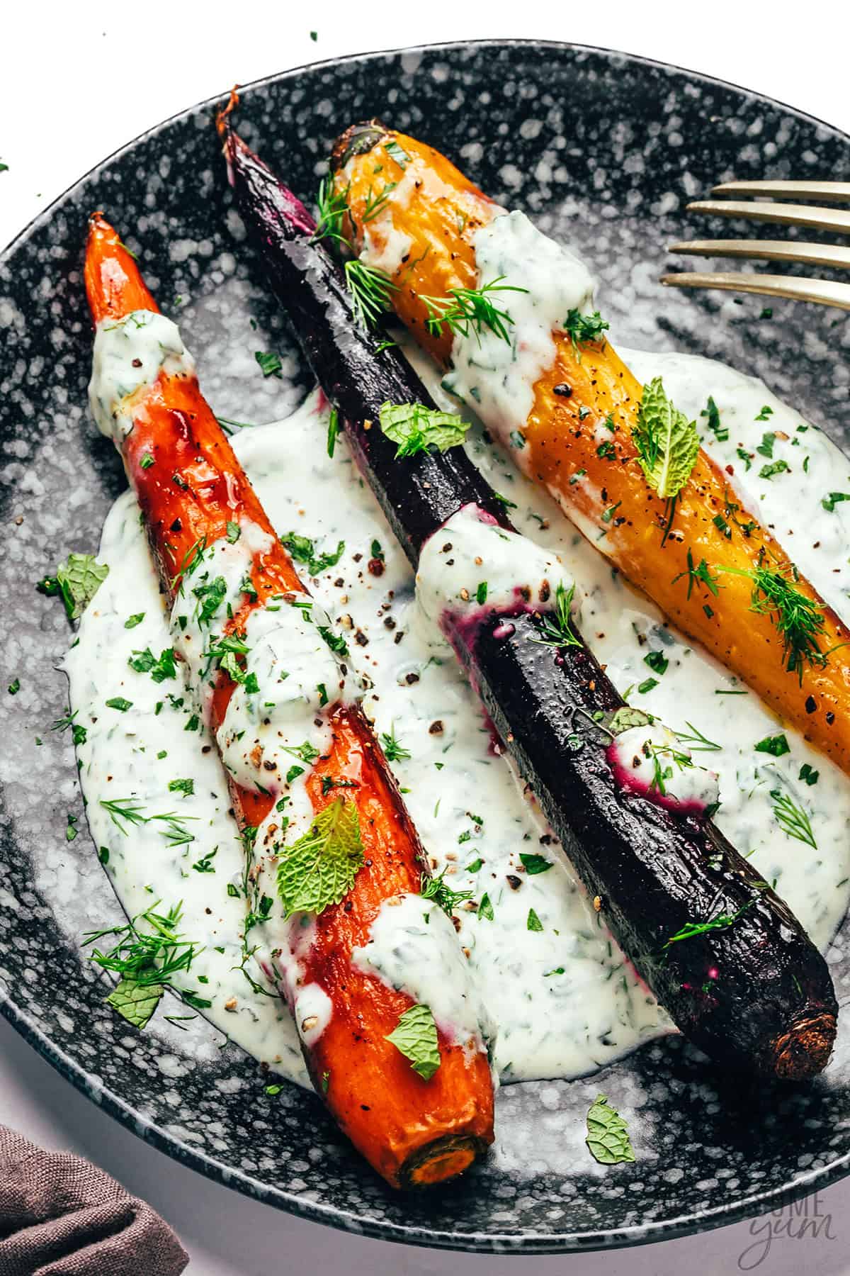 Roasted rainbow carrots topped with creamy yogurt herb sauce.