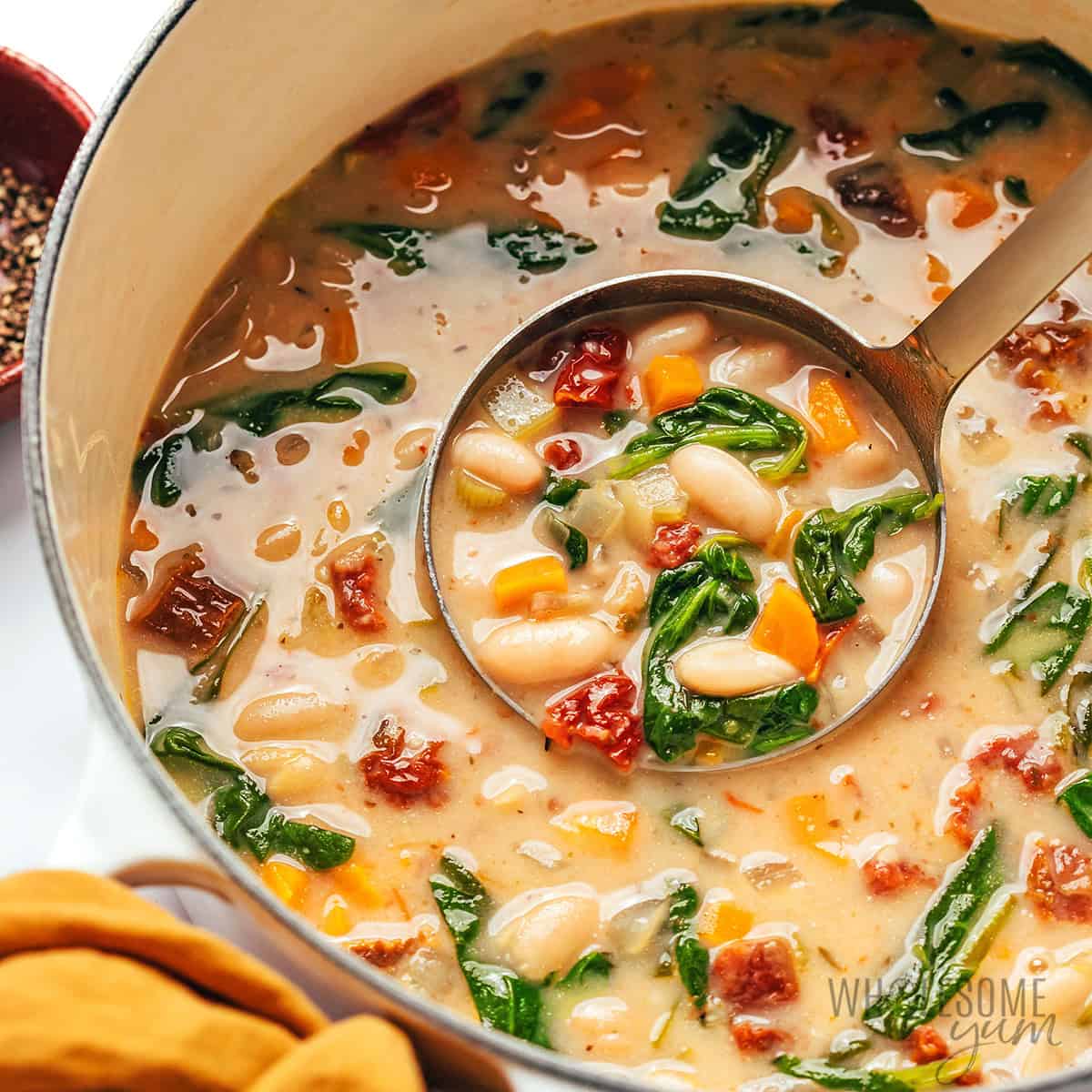 White bean soup in a pot with a ladle.