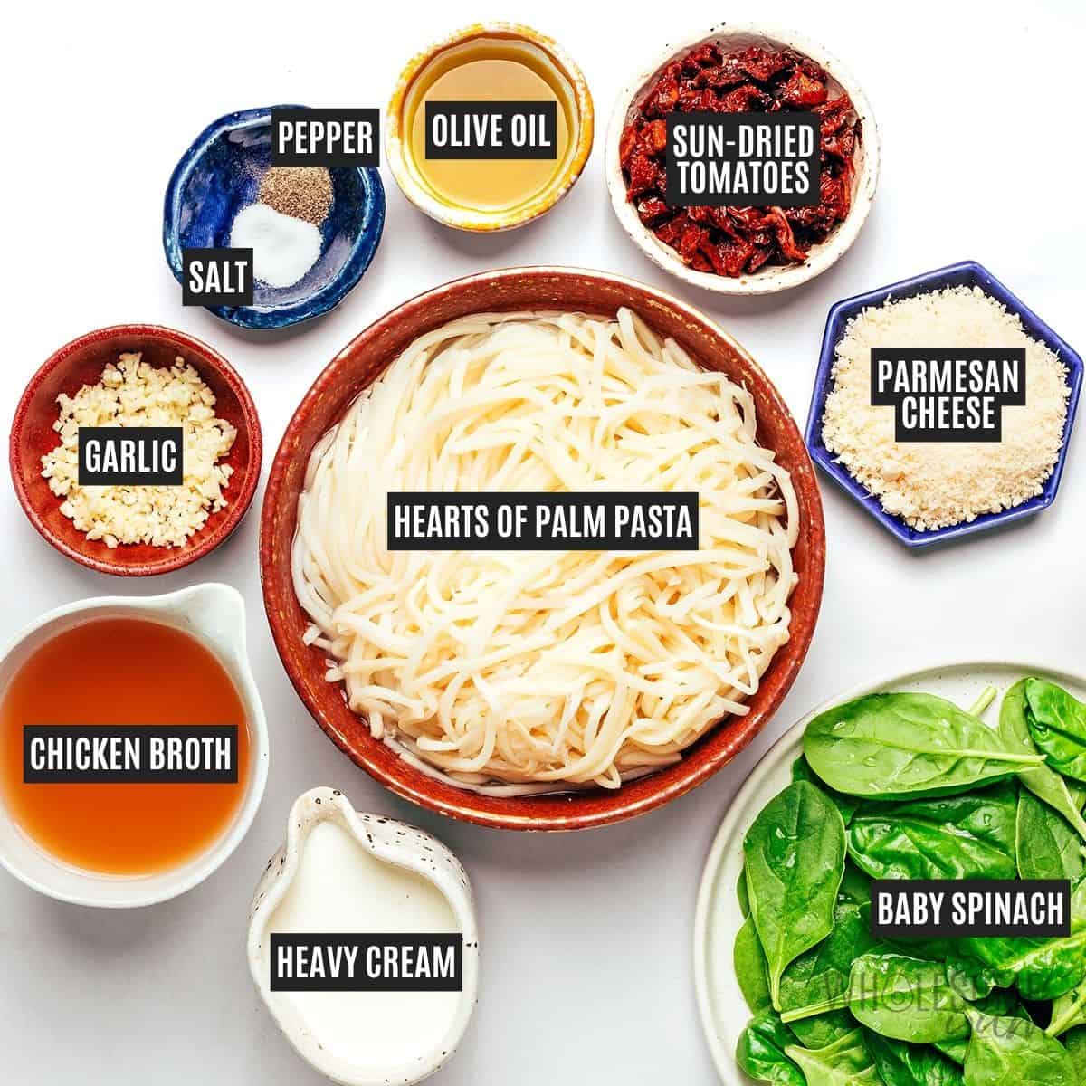 Labeled recipe ingredients: hearts of palm pasta, olive oil, garlic, sun-dried tomatoes, baby spinach, heavy cream, chicken broth, grated parmesan cheese, sea salt, and black pepper.