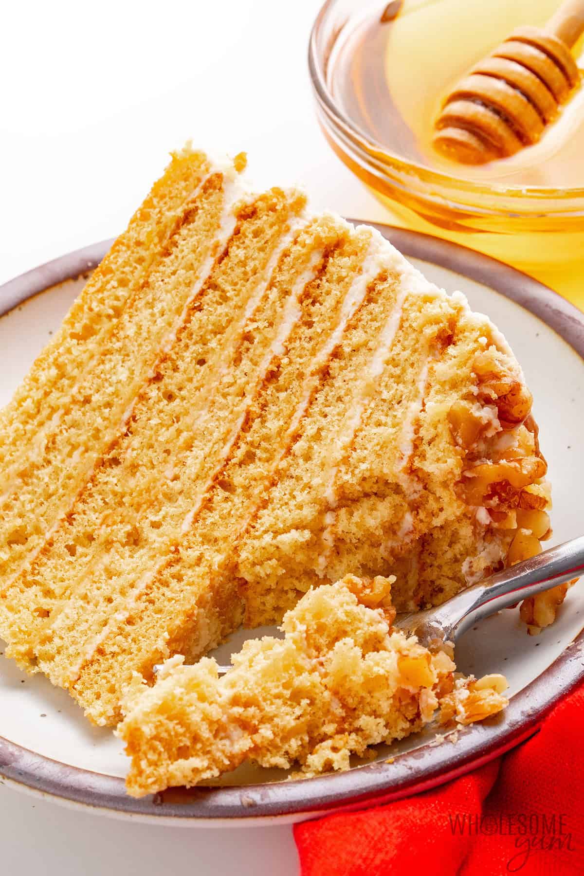 Medovik cake slice on a serving plate with a fork.